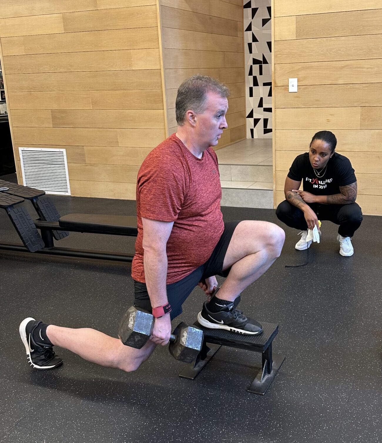 Fit client Conor performing a front foot elevated split squat with dumbbells
