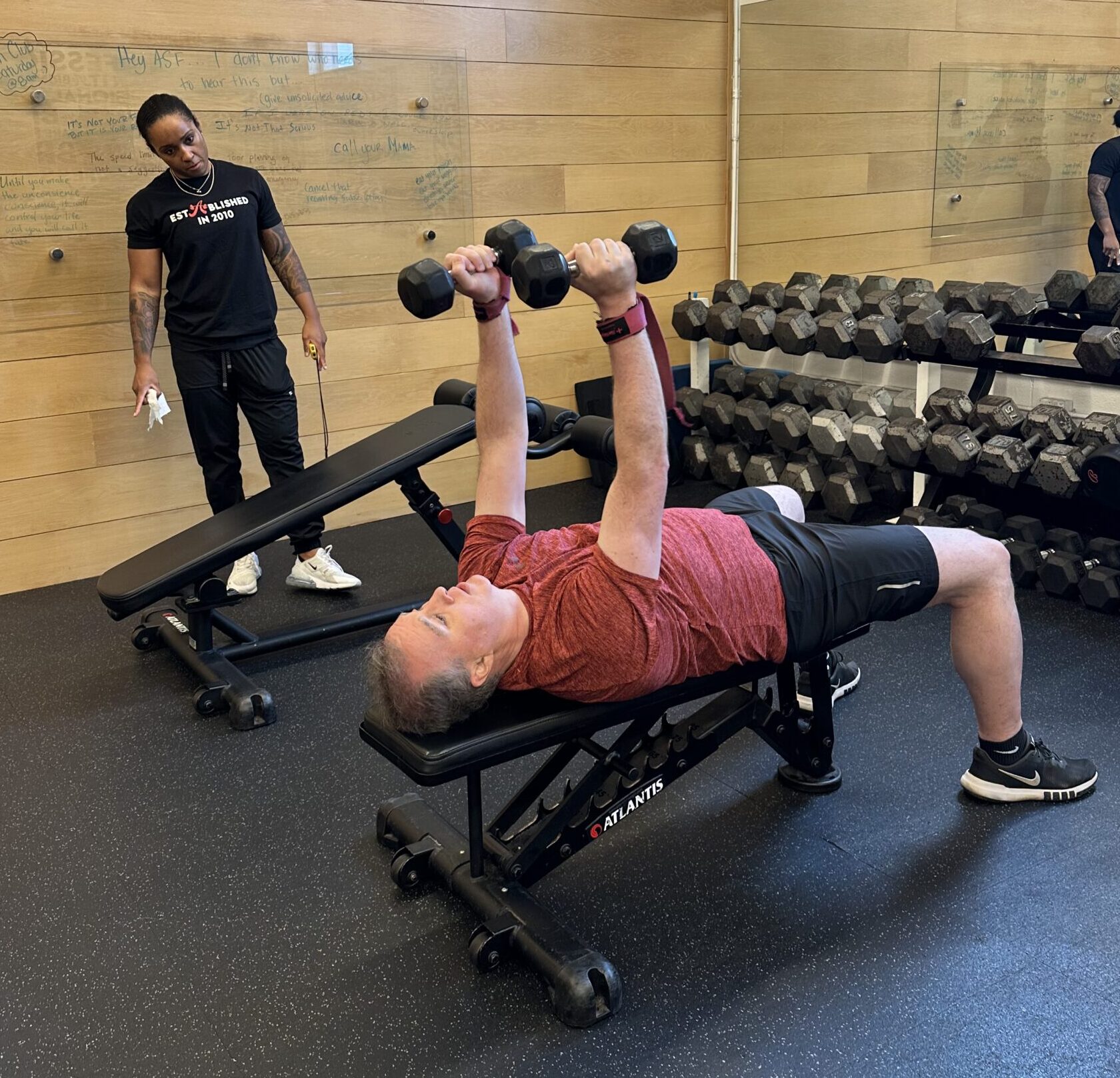 Fit client Conor performing a dumbbell pullover with his coach Sierra