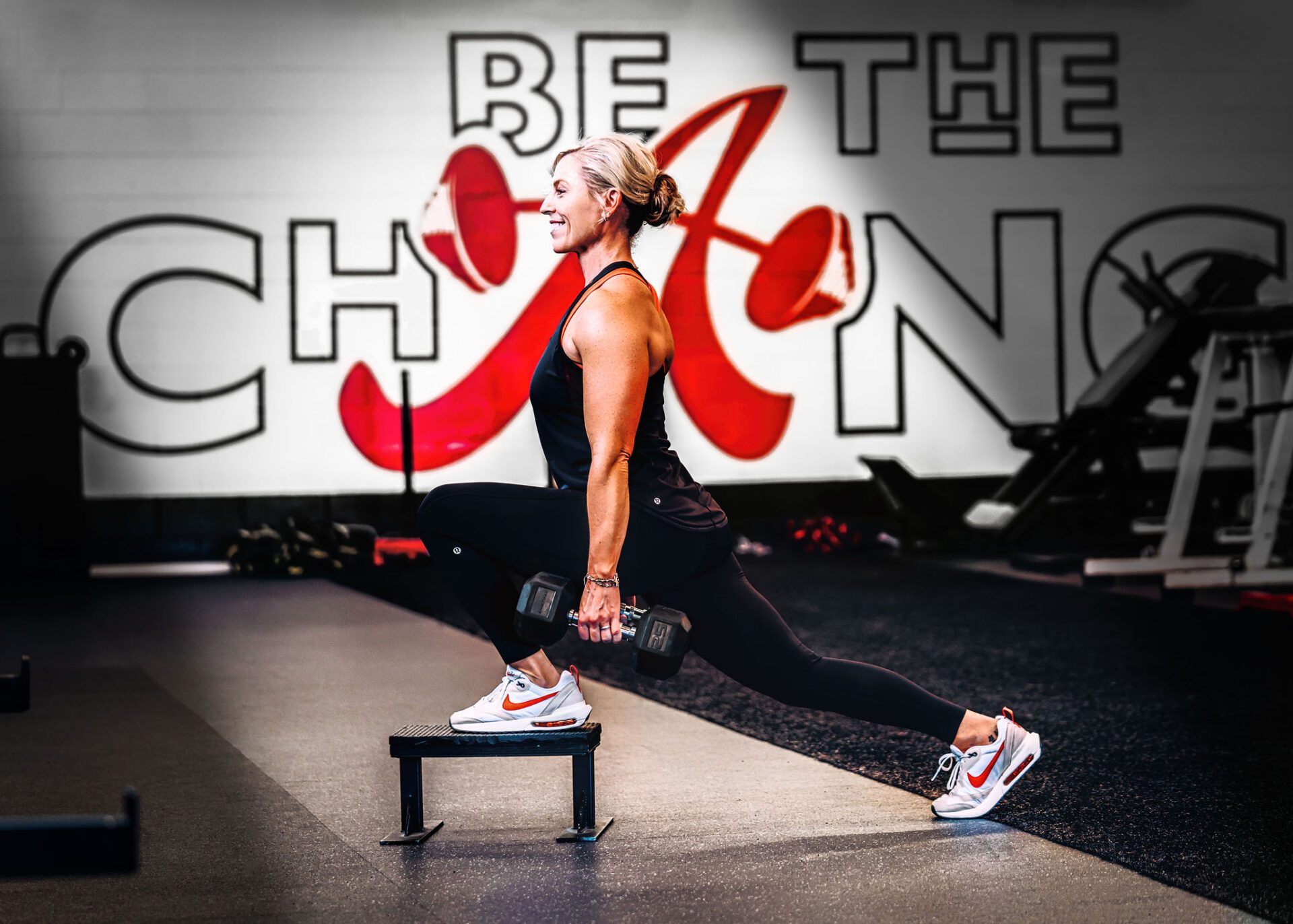 Woman performing a split squat with dumbbells