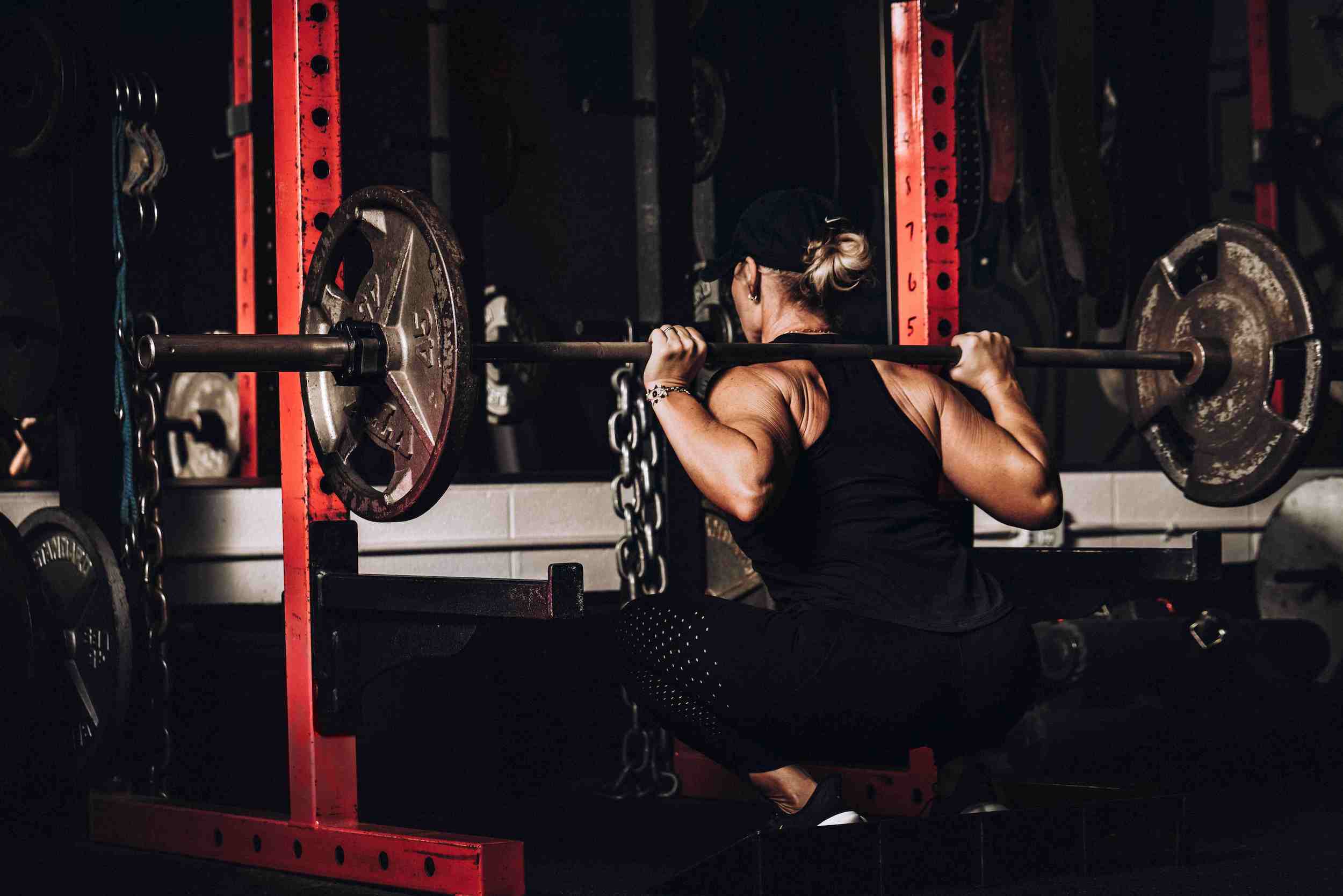 Posterior view of a woman performing a barbell back squat