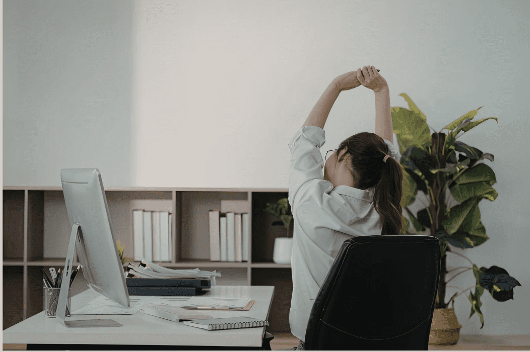 Tech professional stretching at a desk
