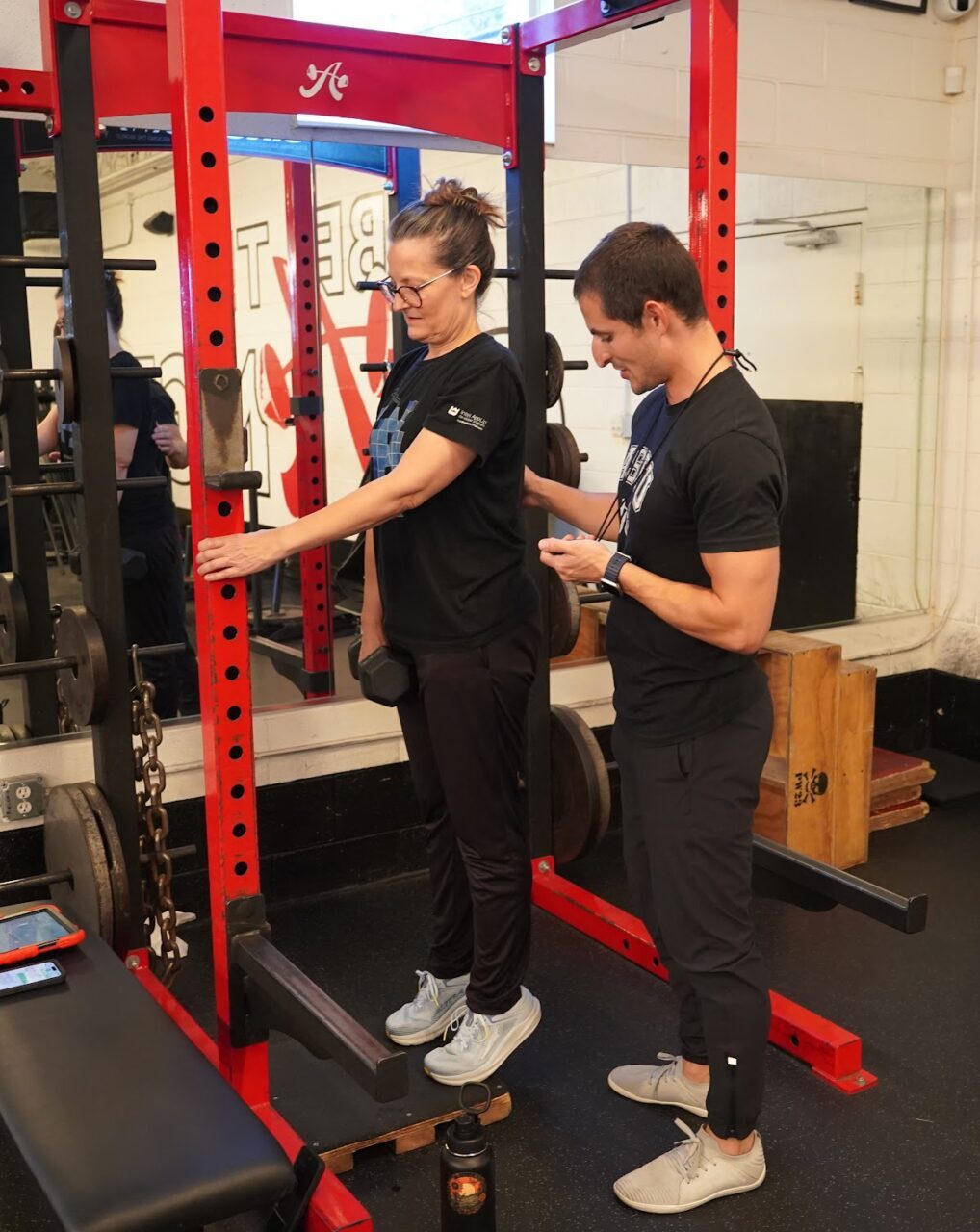 A personal trainer with a client doing calf raises. Personal training is worth the cost