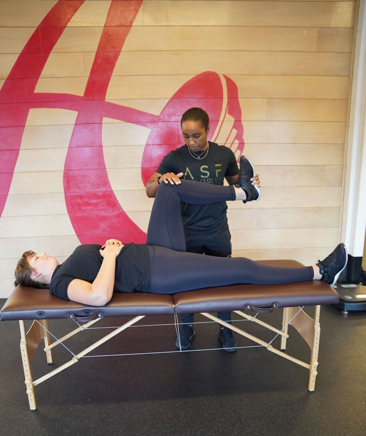 A coach assesses a client's joint mobility