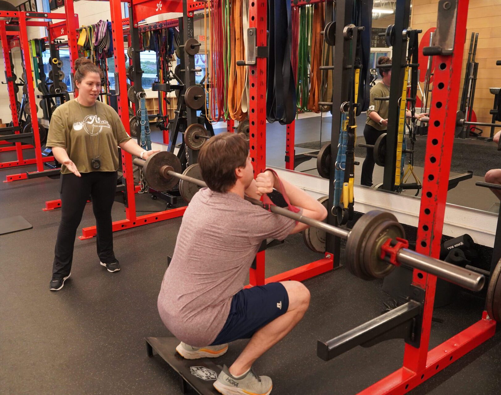 Trainer Ashley coaches a client doing a front squat
